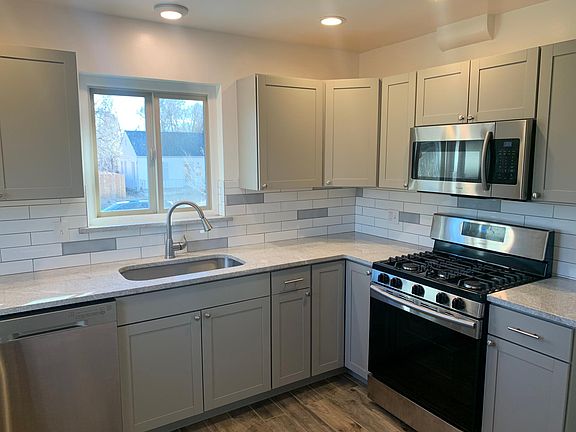 Kitchen with all new appliances: refrigerator, oven/range, microwave, washer/dryer, dishwasher. Also has built in pantry (not visible).