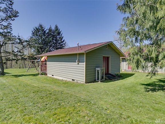 View of the 24' x 24' shop with covered porch.  No water currently hooked up to the shop. Big toy play set belongs to the house for sale next door.
