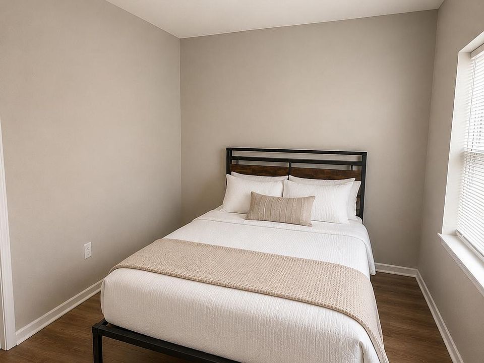 Furnished bedroom with a full-size bed, durable flooring, and a window with blinds for comfortable everyday living.