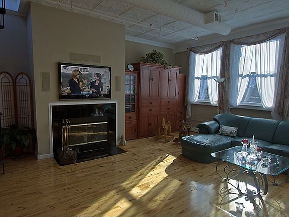 Living room with built in flat screen, fire place, and murphy bed.