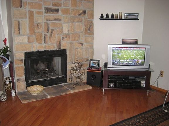 Stone Fireplace in living room with custom hardwood