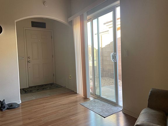 Front door entrance and living room sliding door to a small patio and side gate