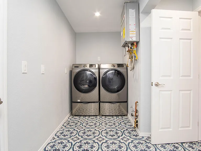 Laundry with dual access from the main bedroom as well as from the garage. Tankless water heater for endless and quick hot water.