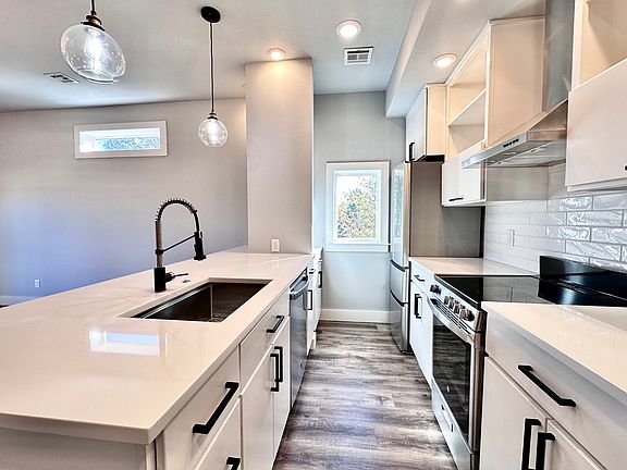 The kitchen features SS appliances, quartz countertops, premium finishes, and a window for bright natural light. Call or text for a tour today!