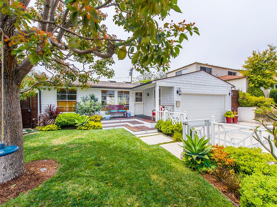 Grass frontyard with enclosed white fence