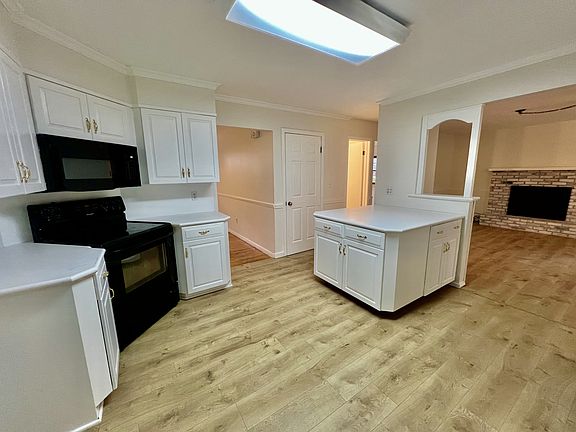 Large kitchen with stove, microwave and new Mohawk hybrid resilient flooring