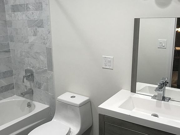 Bathroom with tub and marble tile walls