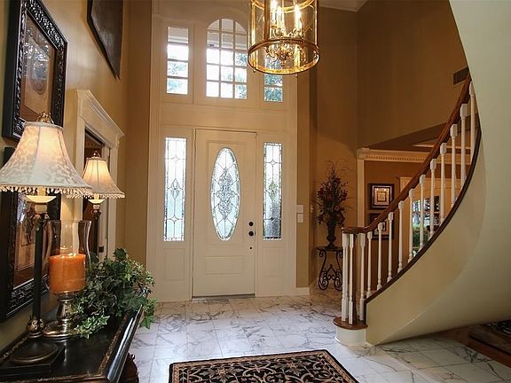 SOARING DRAMATIC 2-STORY ENTRY. As you enter the home, take a moment to admire the winding staircase, marble entry floors, the remodeled study to the right and glamorous dining room to the left. Brilliant designer touches throughout. A must see!