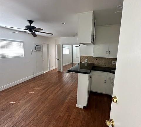 This is what you see when you first enter the unit. The ceiling fan, wall air-conditioning unit, mirrored closet door. The kitchen is also evident and a nice large window bringing Beautiful natural light into this area.