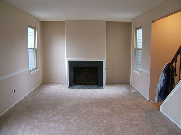 Living room with fireplace, freshly painted and new carpet.