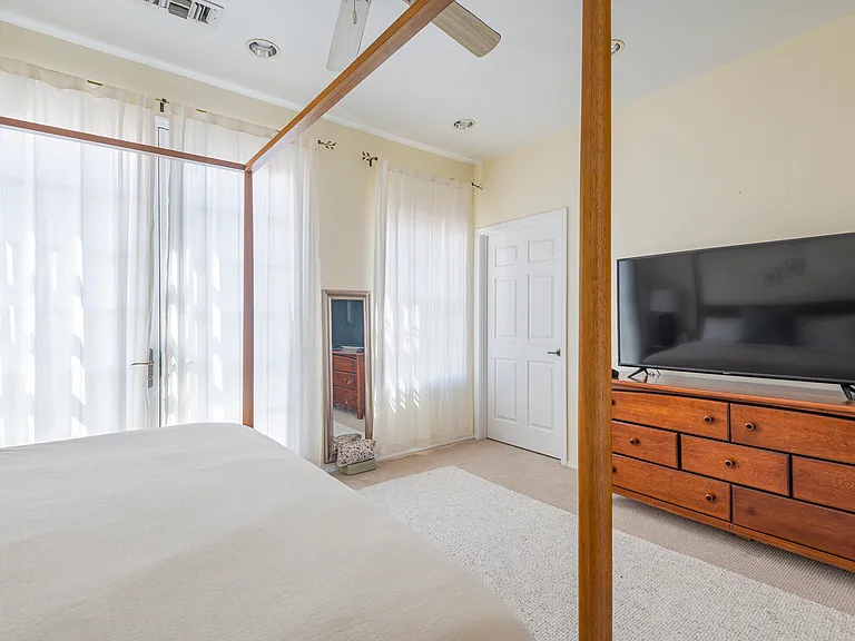 Third-floor master bedroom. French doors lead to a Spanish style balcony overlooking the courtyard.