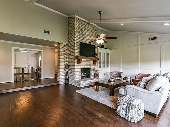 There are beautiful wood floors, gas-log fireplace with a custom mantle, vaulted ceilings, recessed lighting, built-ins and crown molding.
