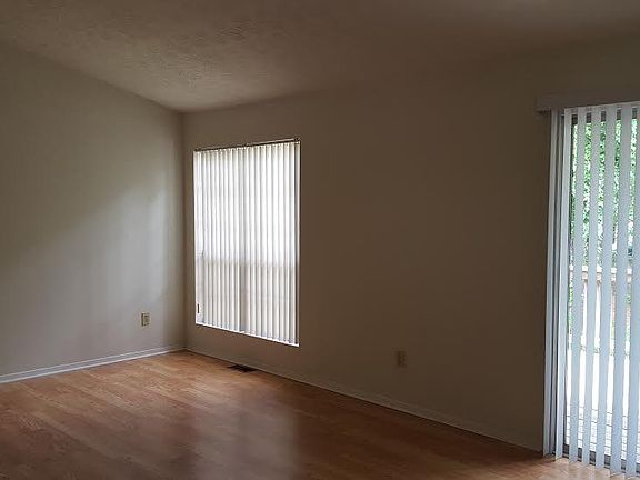 Family room featuring a vaulted ceiling, plenty of windows with glass sliding doors to deck, and open to the foyer and kitchen.