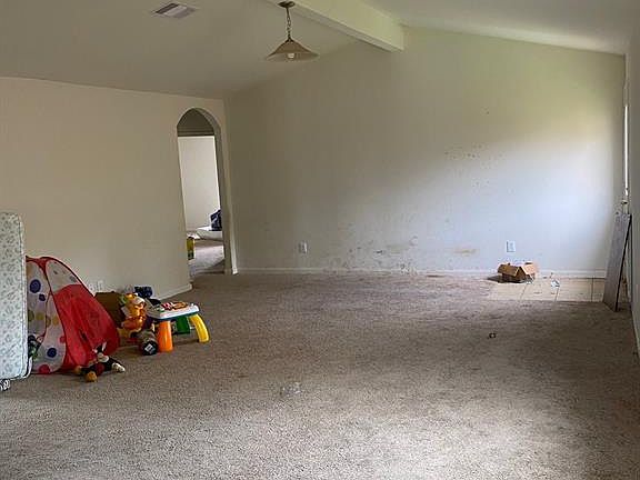 This family room is huge and features a lovely vaulted ceiling with a central beam. Imagine the possibilities for a room with these architectural features!