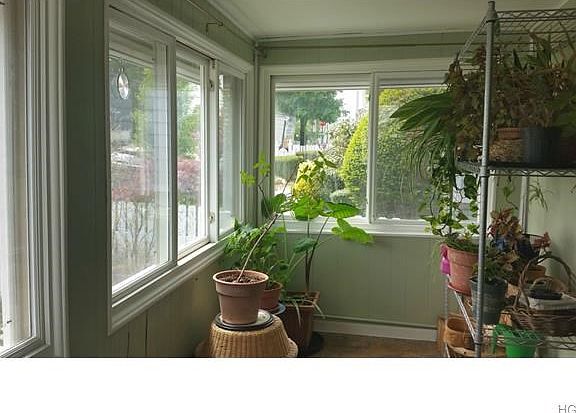 Enclosed porch/sunroom, facing south, ideal for indoor plants.