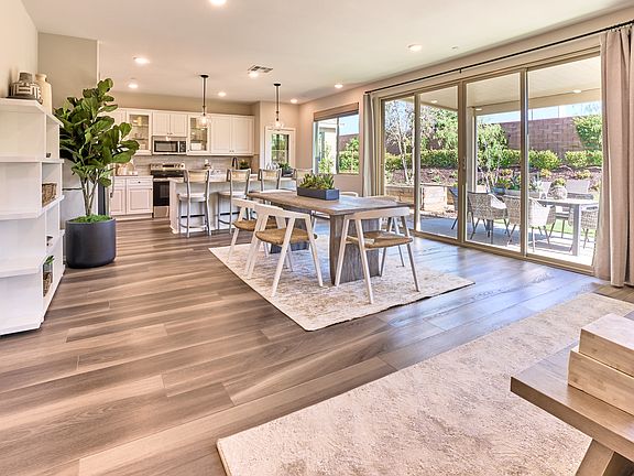 A spacious and modern open-plan kitchen and dining area with wooden floors, large windows overlookin