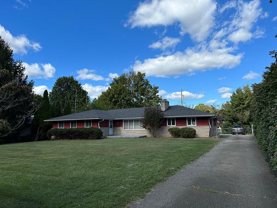 The front view of the house with gated long driveway from the street.