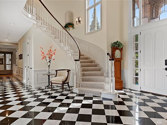 The foyer with 30-foot ceilings, crystal chandelier (with motorized lowering device for easy cleaning), new marble floors and sweeping bridal stairway. 