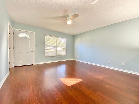 Over-sized living room with view of the front door and window. Includes remote controlled ceiling fan