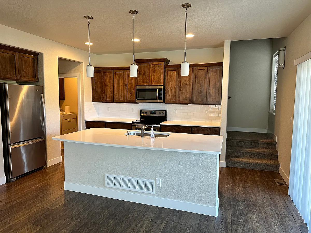 Kitchen with quartz counter, stainless refrigerator and freezer. Alder wood cabinets. - 1946 Pikes Peak Dr