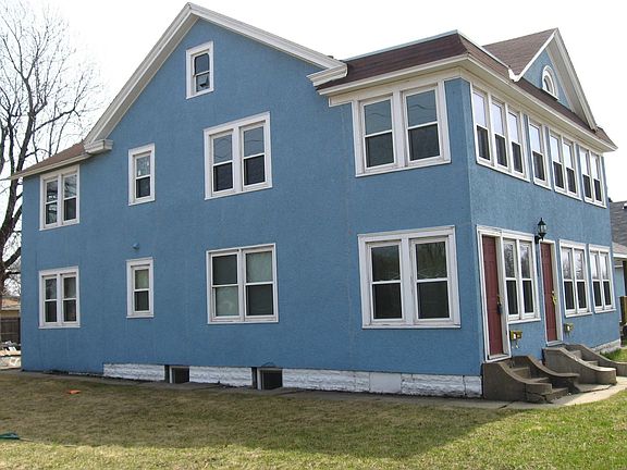 Exterior features separate entrances in front and back and ample parking.