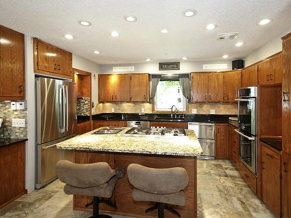 Gourmet kitchen has 3 refrigerators, warming drawer, double oven, built in coffee maker, dishwasher, gas cooktop, granite countertops, under cabinet lighting and more!