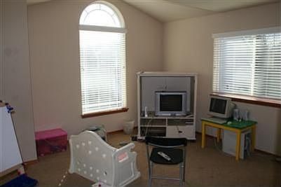 Bonus room. Notice the cathedral ceiling, large arched window allowing ample natural light.