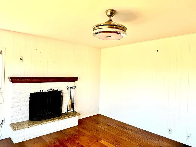 Large wood burning fireplace with granite hearth and custom mantle