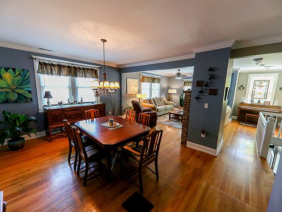 Large dining room area with room for entertaining and ample lighting. Stairs are to the right down to the front of the home.