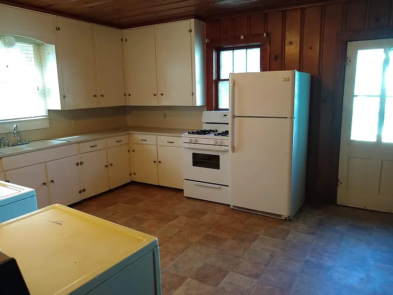 Kitchen with lots of cabinets, range, refrigerator, washer and dryer