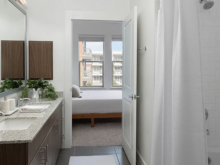 Apartment Bathroom with large soaking tub, double sink, and tile flooring.