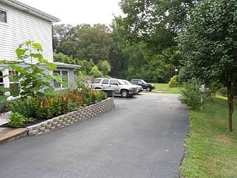 L-shaped blacktop driveway for lots of parking