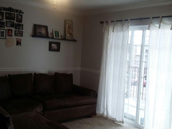 Family room w/ ceiling fan and sliding glass door.