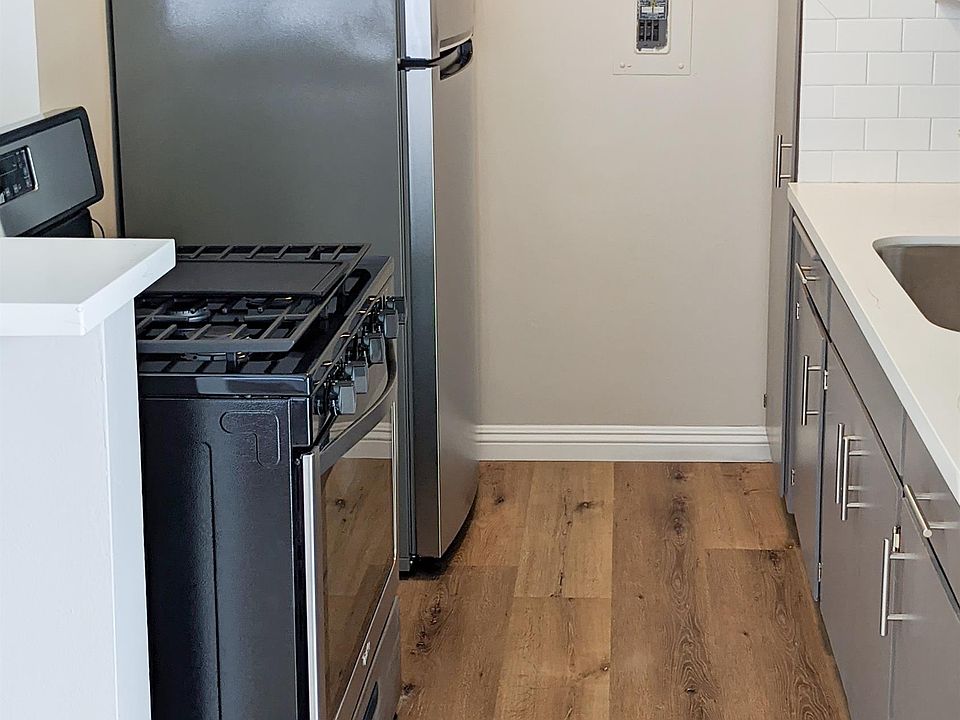 Galley kitchen- stainless appliances, quartz countertop, stainless steel sink, backsplash