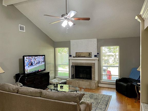 Open and bright living room with views to the back yard. Fireplace and wood floors.