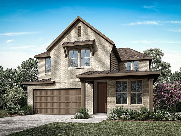 A two-story house with a gabled roof, surrounded by lush greenery and a paved driveway leading to a