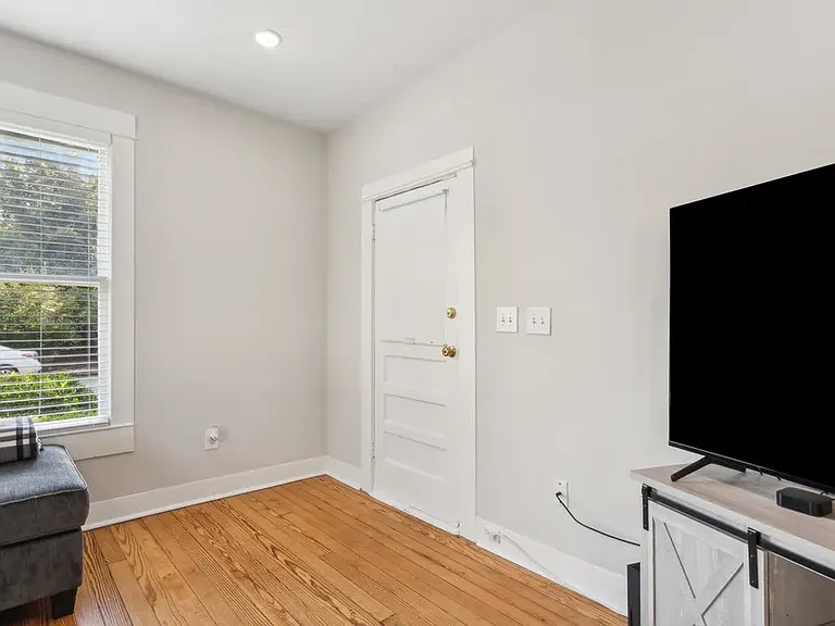 Living room looking back at front door with window facing Alston Ave