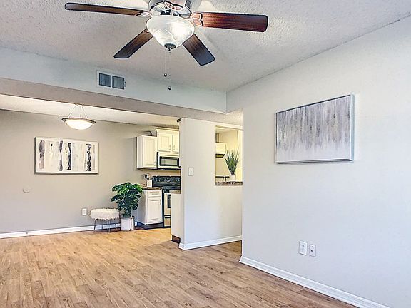 Airy open floor plans with wood-style flooring and ceiling fans offer an elegant, communal living experience.