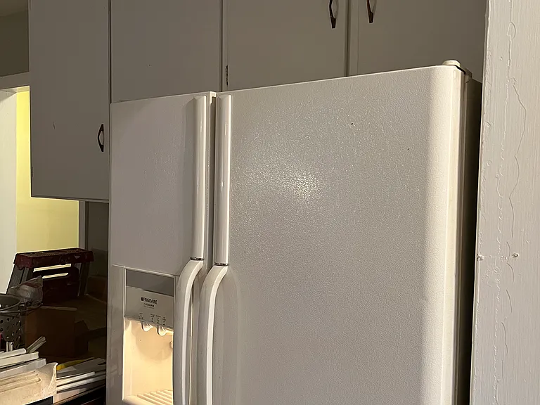 Refrigerator with ice maker and water dispenser. Many cabinets.