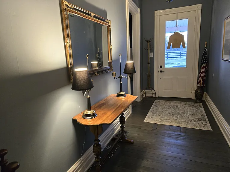 Hall entry view from back to front of house. Note restored original plank flooring.