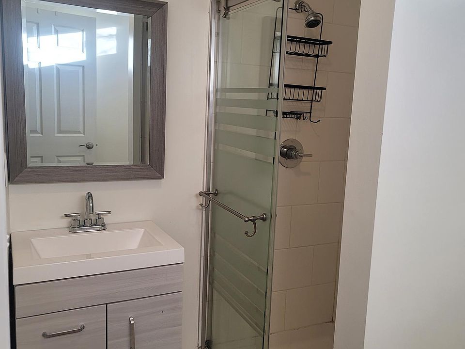 Beautifully tiled shower with modern vanity and flooring.