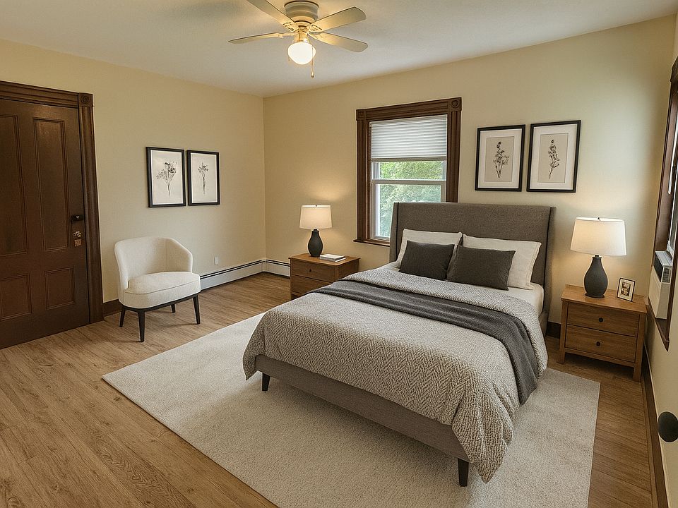 Comfortable bedroom virtually staged with queen bed, natural light, and hardwood floors.