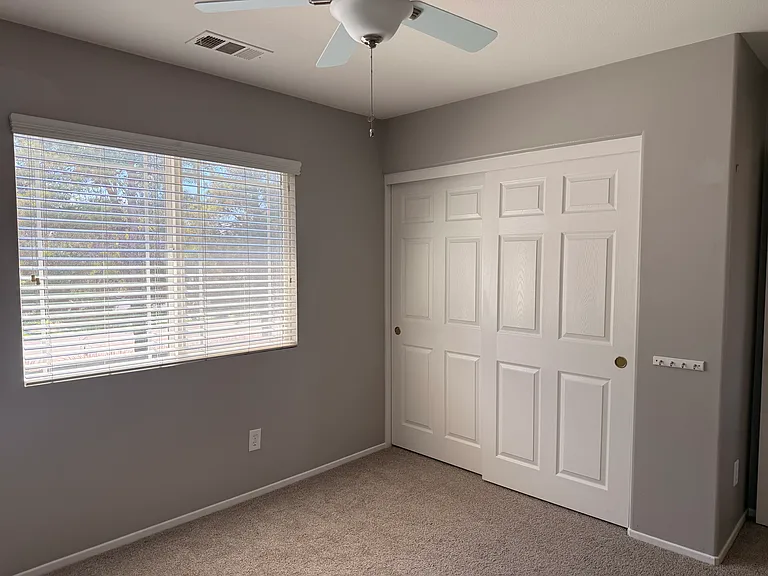 Guest bedroom #2 with big window and ceiling fan, spacious closet.