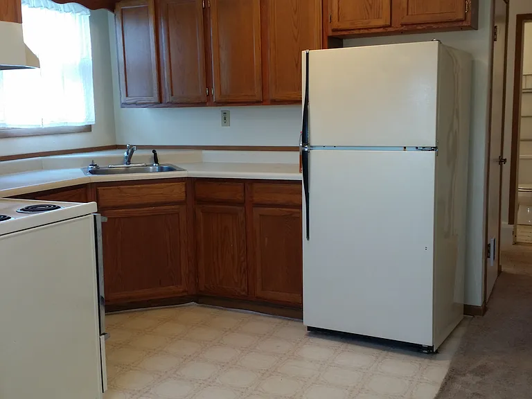 Kitchen with generous amount of cabinets, range/oven and fridge.