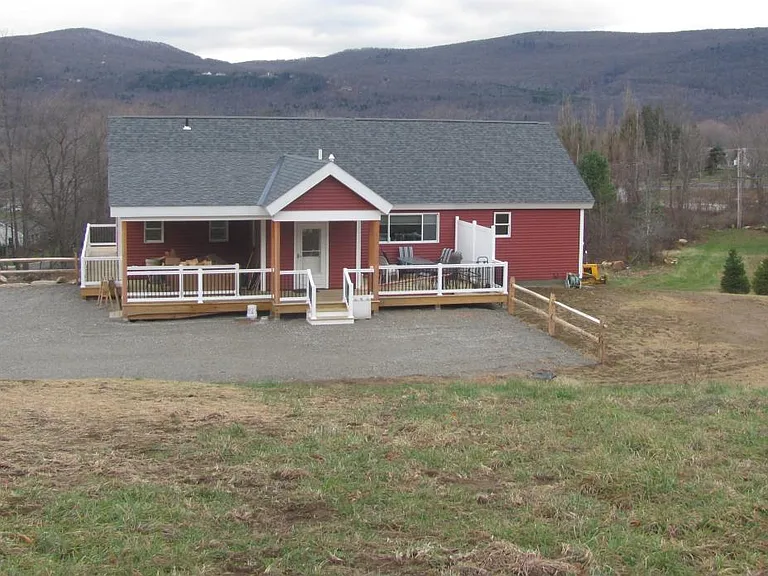 The view of the rear of the home with covered and open porch