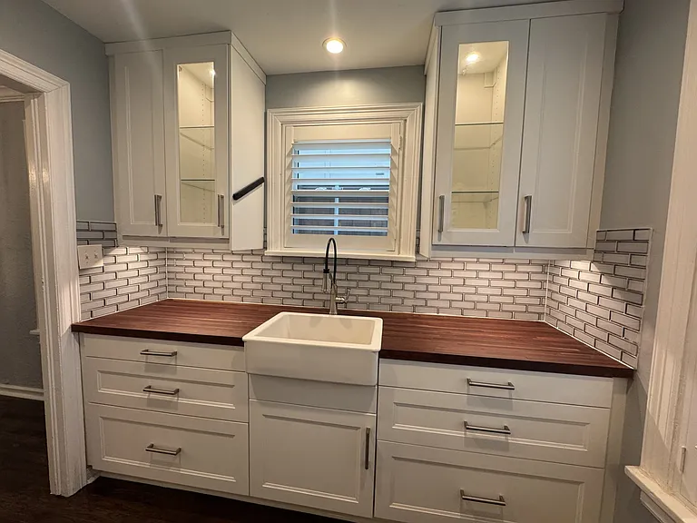 Completely renovated kitchen, with ample storage, butcher block countertops and new custom plantation wooden shutters.