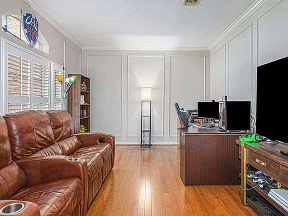 The entry is flanked by this formal living room that could easily be used as a study! Plantation shutters, crown molding and box molding finishes out the space!