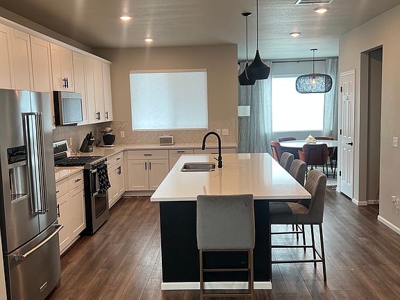Fully stocked gourmet kitchen with dual ovens, gas stove, large french door Kitchen Aid fridge, tons of cabinets, and large pantry
