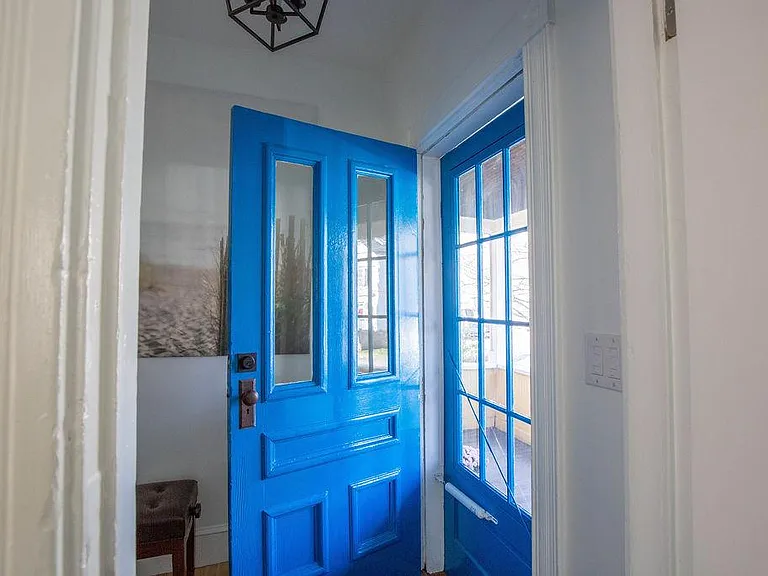 Front door leads to front porch with rocking chairs and quiet tree lined street steps to shops and restaurants.