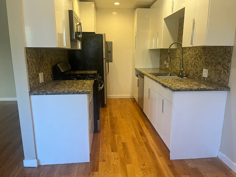 KITCHEN HAS CUSTOM MODERN CABINETS AND GRANITE COUNTERTOPS